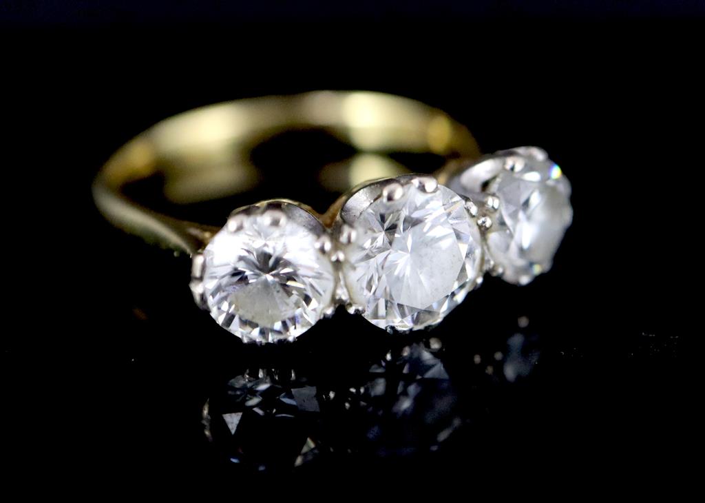 A modern 18ct gold and three stone brilliant cut diamond ring,